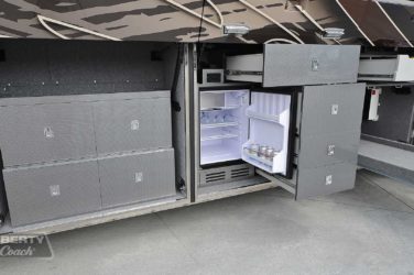 2017 Elegant Lady #5371 exterior entry side undercarriage close-up of small refrigerator outside bay of motorcoach