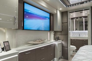 2020 Elegant Lady #860 motorcoach interior view of bedroom shelving wall unit with TV