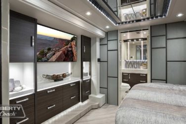 2021 Elegant Lady #5376 motorcoach interior view of bedroom shelving wall unit with TV