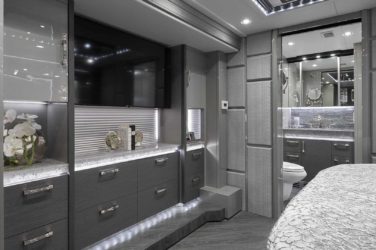 2021 Elegant Lady #869 motorcoach interior view of bedroom shelving wall unit with TV