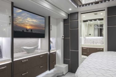 2021 Elegant Lady #870 motorcoach interior view of bedroom shelving wall unit with TV