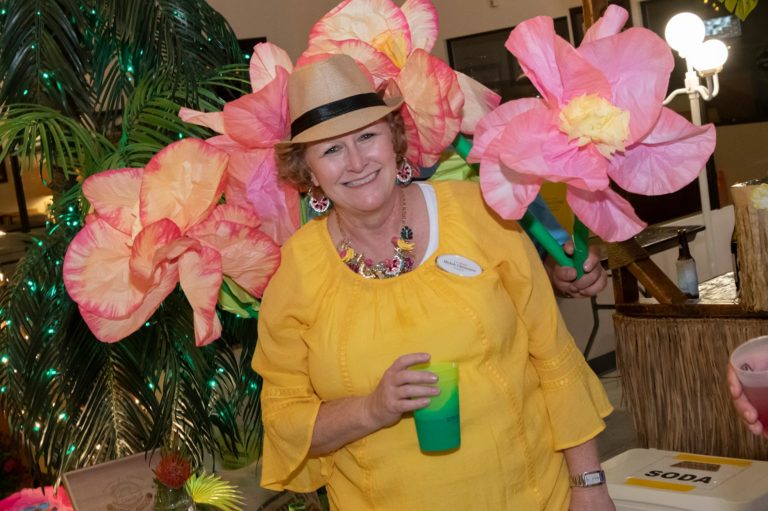 20th Annual Rally - Woman Enjoying Drink In-Front of Flowers