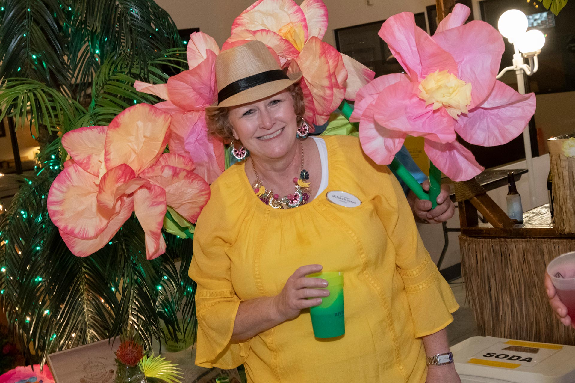20th Annual Rally - Woman Enjoying Drink In-Front of Flowers