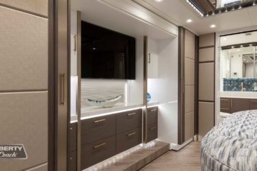 2022 Elegant Lady #884 motorcoach interior view of bedroom shelving wall unit with TV