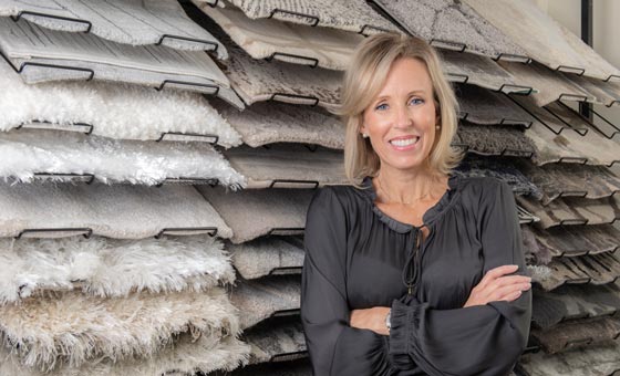 Kim Konigseder standing in front of carpet samples