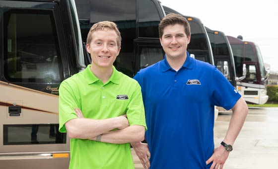 Alex and Nick Konigseder standing in front of motorcoaches