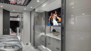 2023 Liberty Coach #899 motorcoach interior view of bedroom shelving wall unit with TV